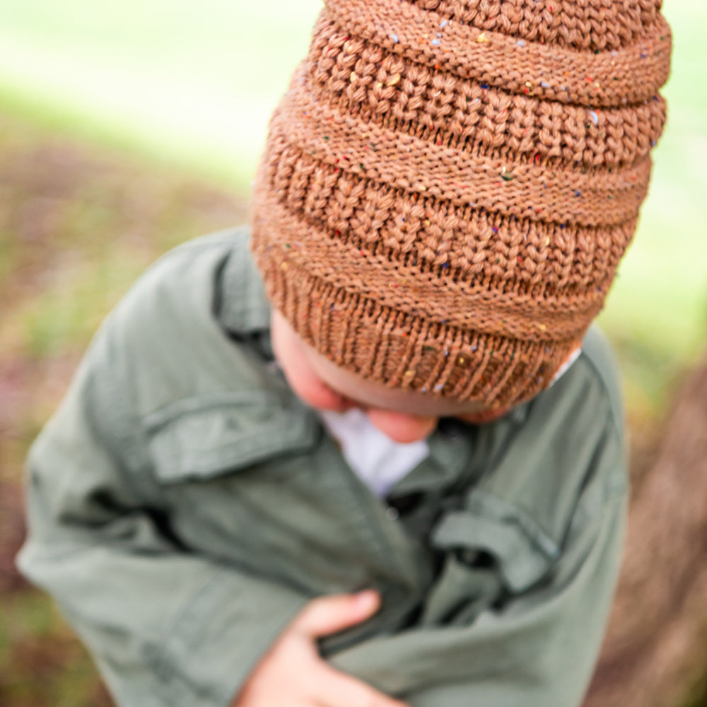 Child looking down while wearing the Mocha Byron Beanie, showing the textured knit