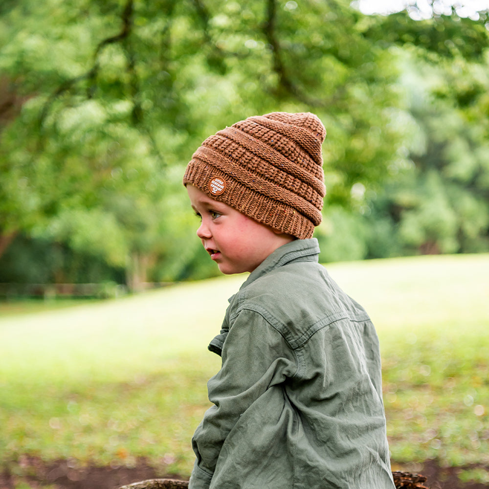 Child wearing the Mocha Byron Beanie while walking through a park