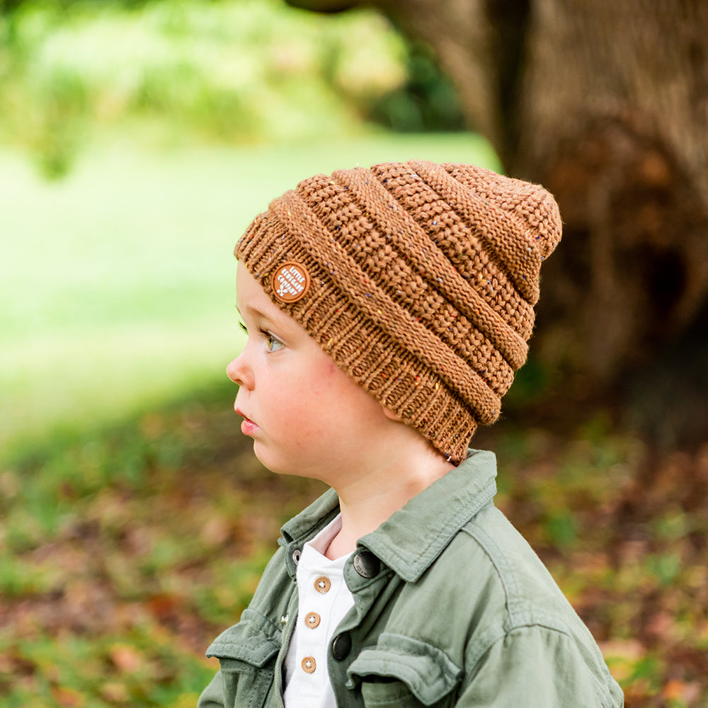 Side view of a child wearing the Mocha Byron Beanie outdoors