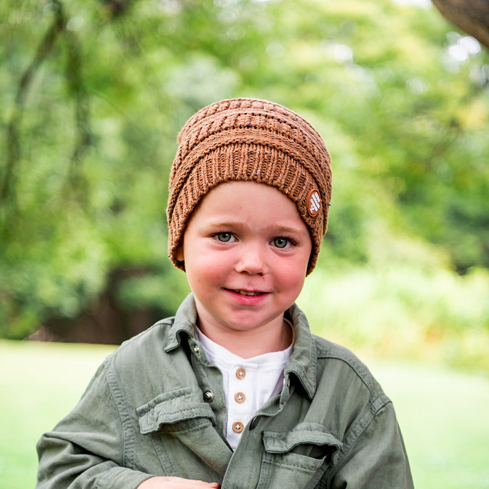 Smiling child wearing the Mocha Byron Beanie outdoors