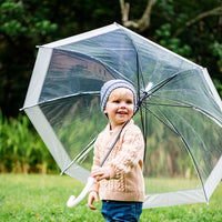 Child wearing the Slate Byron Beanie while holding a clear umbrella outdoors