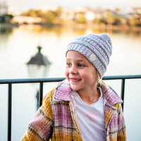 Child wearing the Speckle Byron Beanie during an outdoor waterfront outing