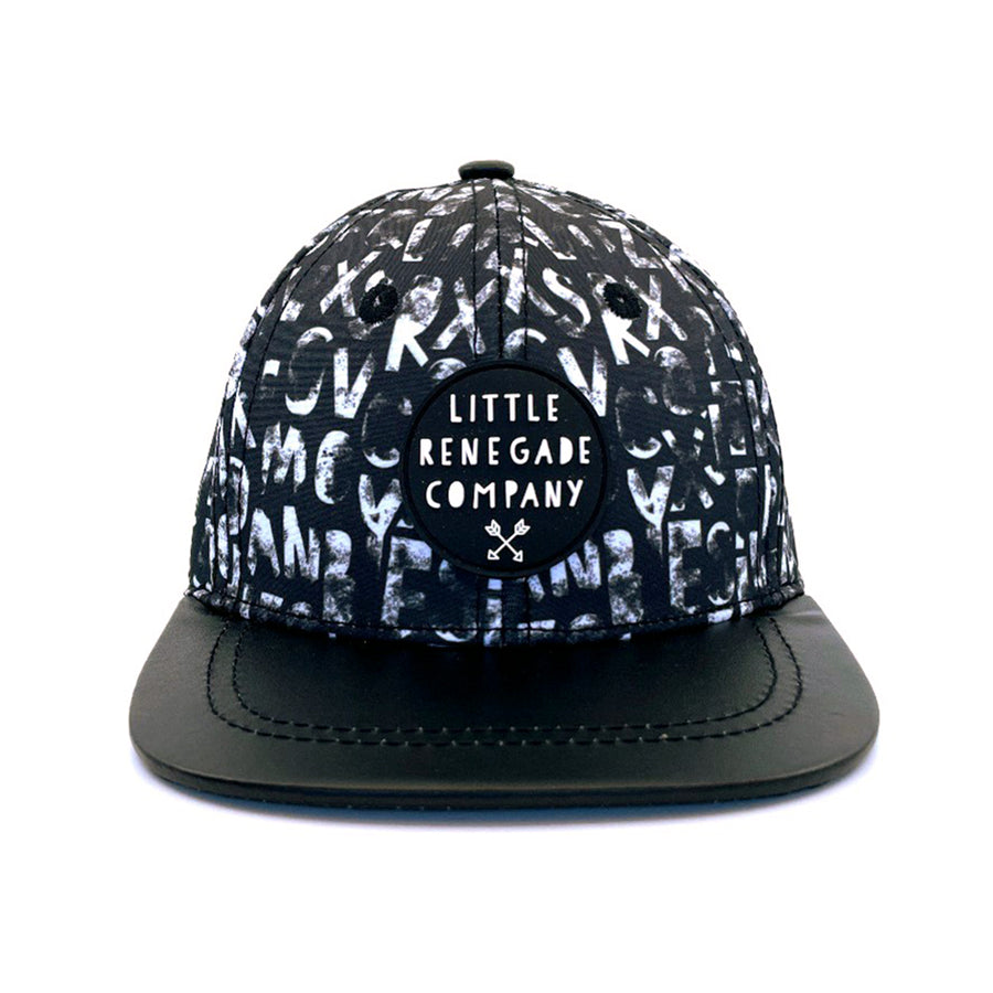 A black cap featuring a monochrome uppercase alphabet print and a black PU leather peak. The front displays a circular patch with the "Little Renegade Company" logo, adding a stylish touch.