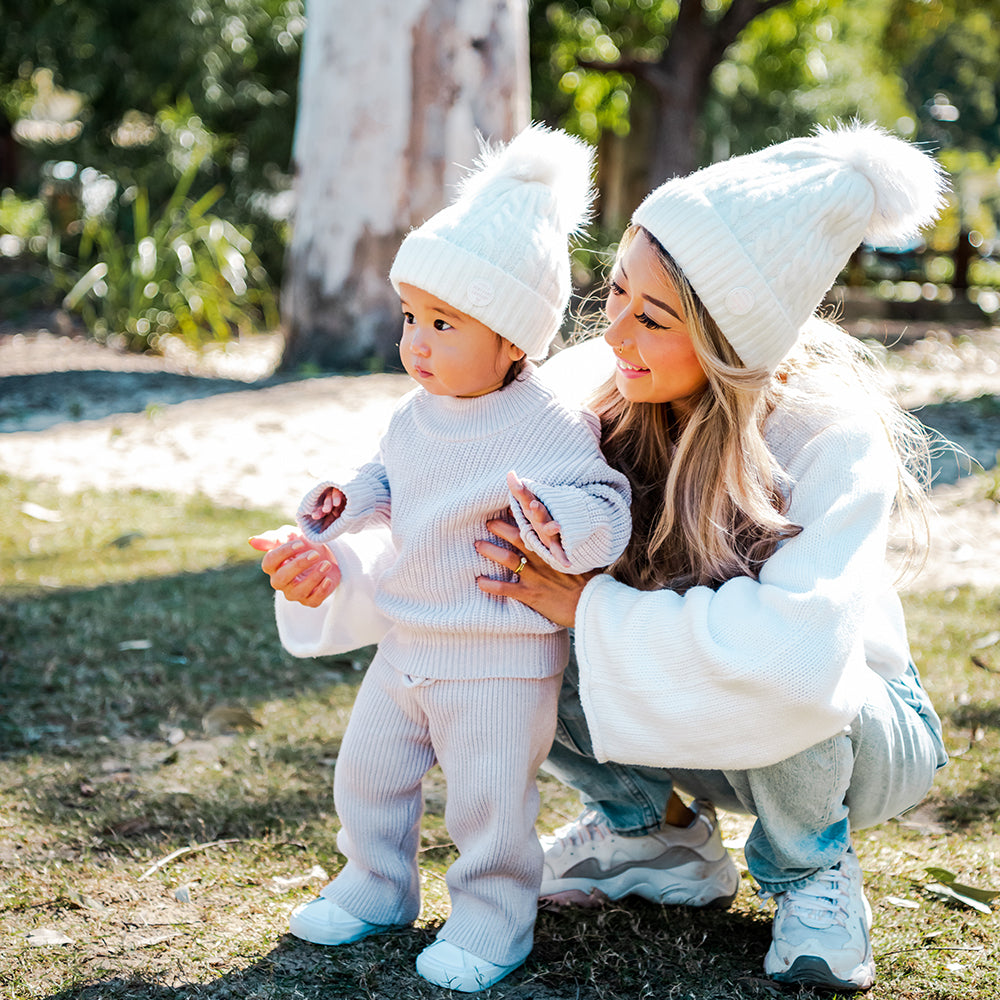 Adult and toddler wearing White Aurora Beanies together outdoors