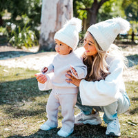Adult and toddler wearing White Aurora Beanies together outdoors