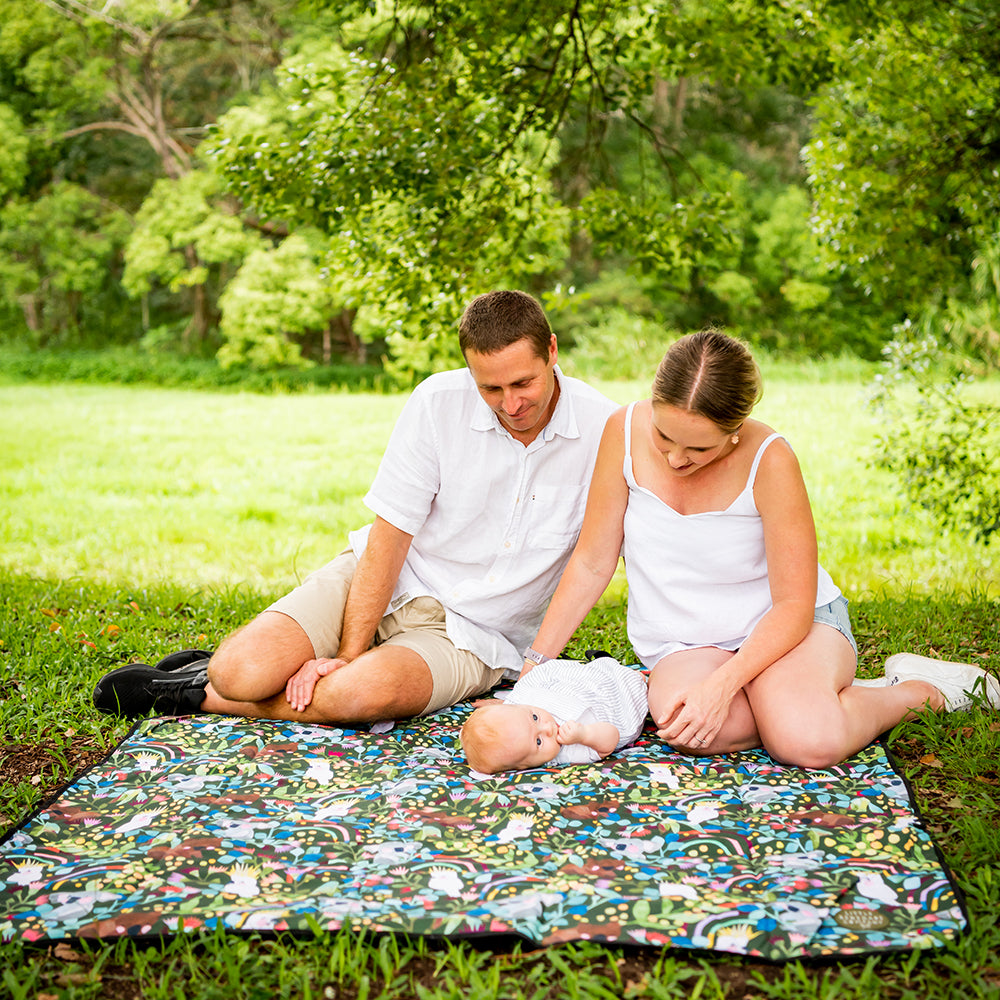 Family sitting together on the Aussie Natives Adventure Mat on the grass