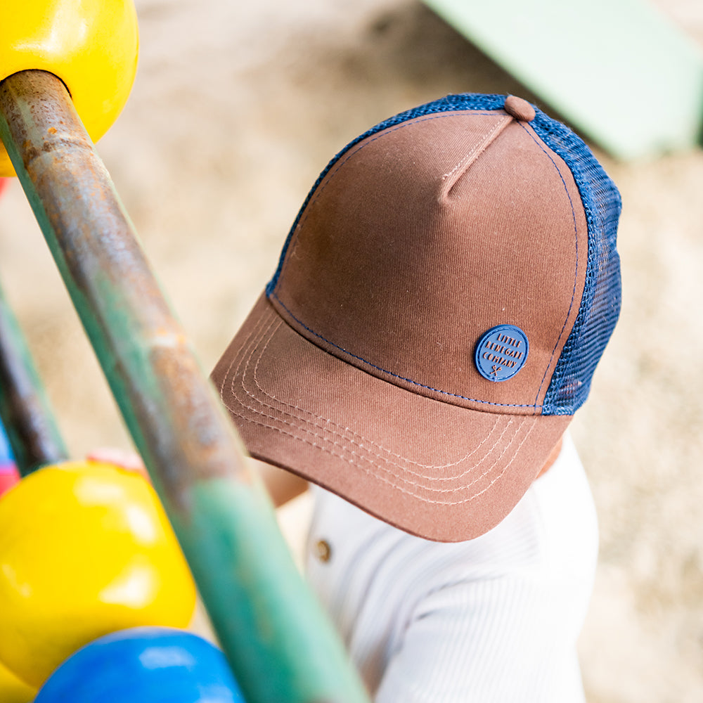 Close-up of the Chocolate Trucker Cap showing its structured brown front and curved peak