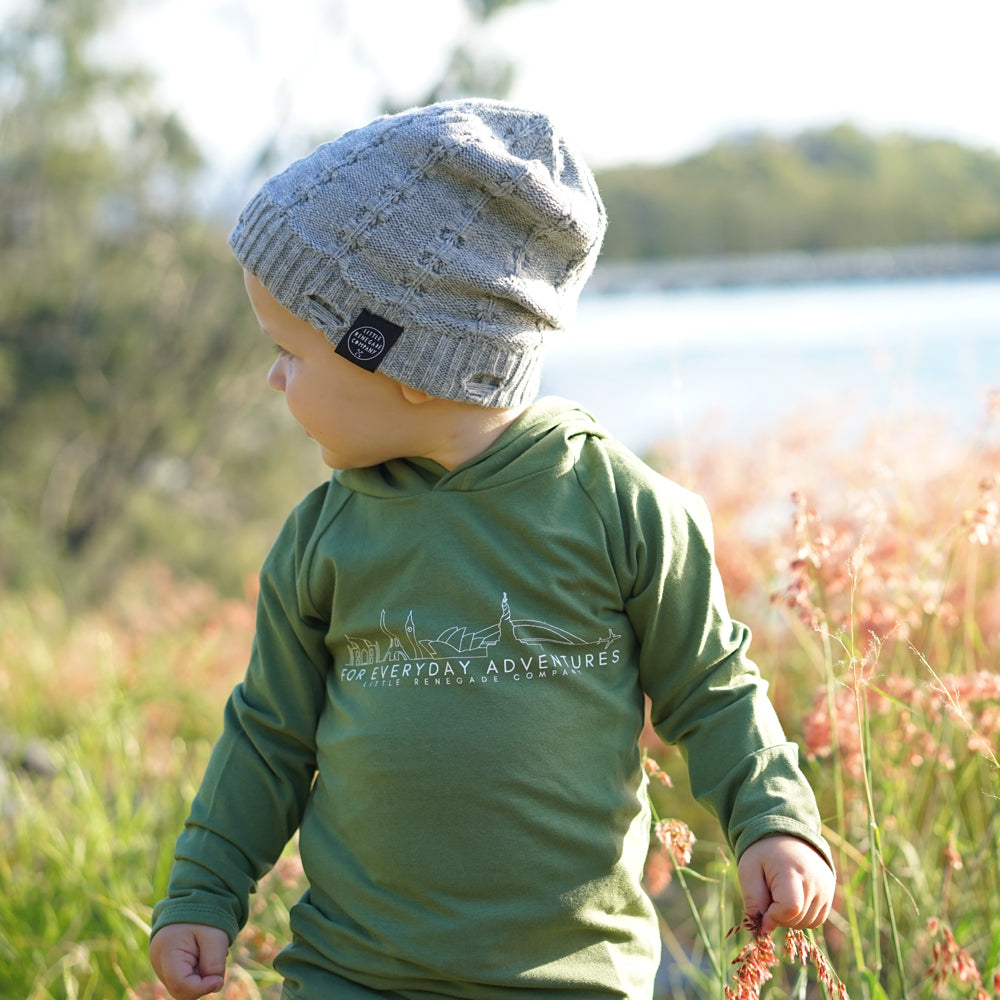 Back view of a child wearing the Grey Everest Beanie outdoors near the water