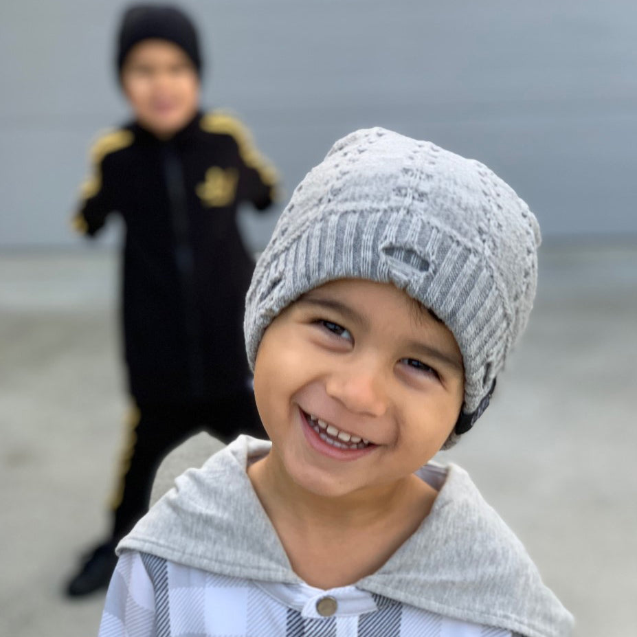 Smiling child wearing the Grey Everest Beanie outdoors