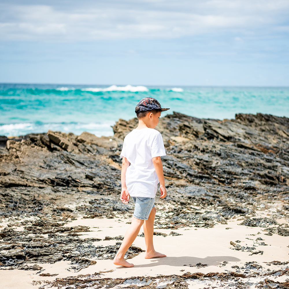 Child wearing a Little Renegade 5 Panel Cap outdoors