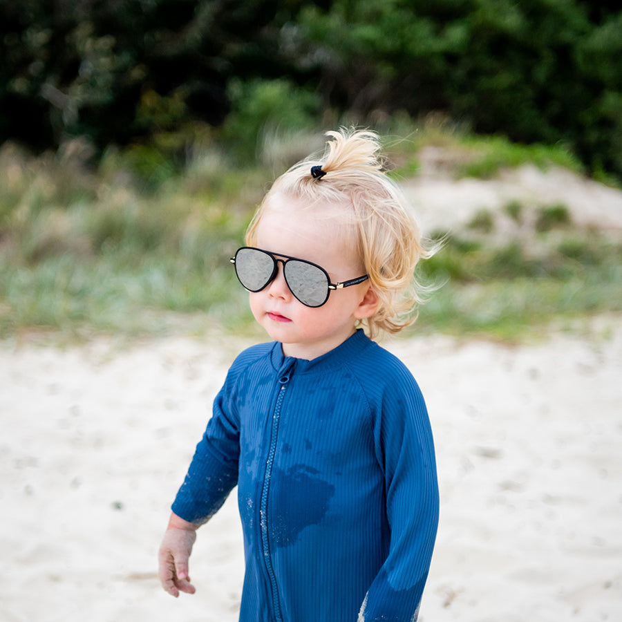 Boy wearing black Patrol kids sunglasses at the beach