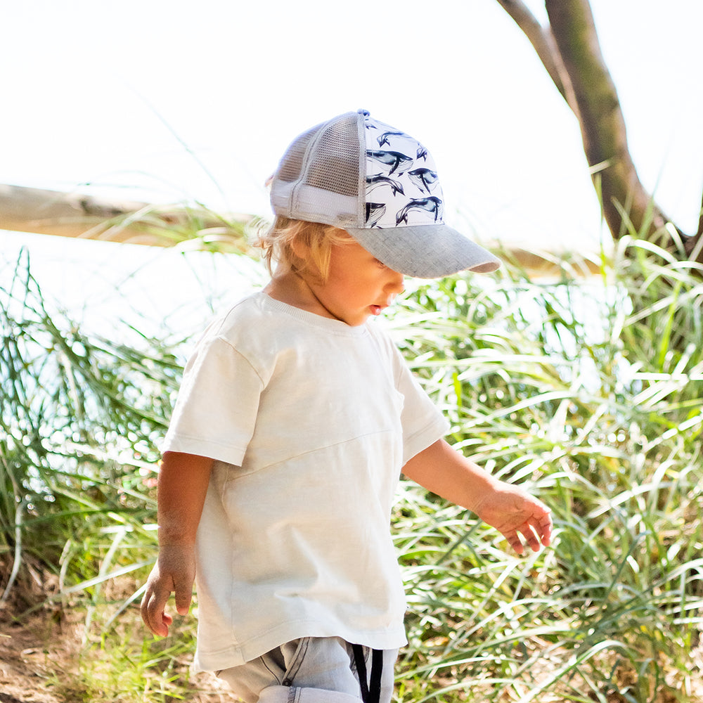 Child wearing the Pod Trucker Cap from the side and back showing its breathable grey mesh