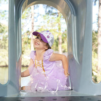 Child wearing the Popsicle Trucker Cap during outdoor play in a purple outfit