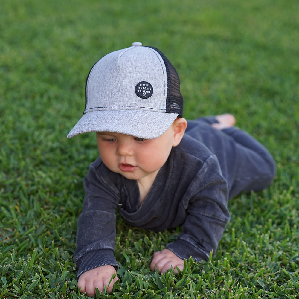 Child wearing the Shadow Trucker Cap while playing outdoors on grass