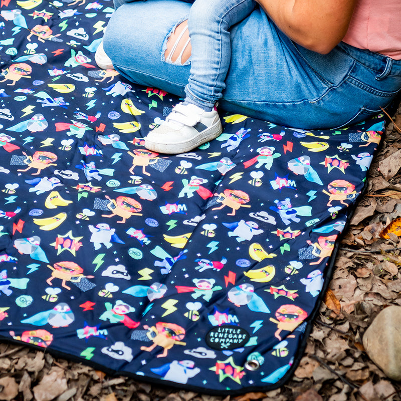 Family using the Superhero Pals Adventure Mat on the grass