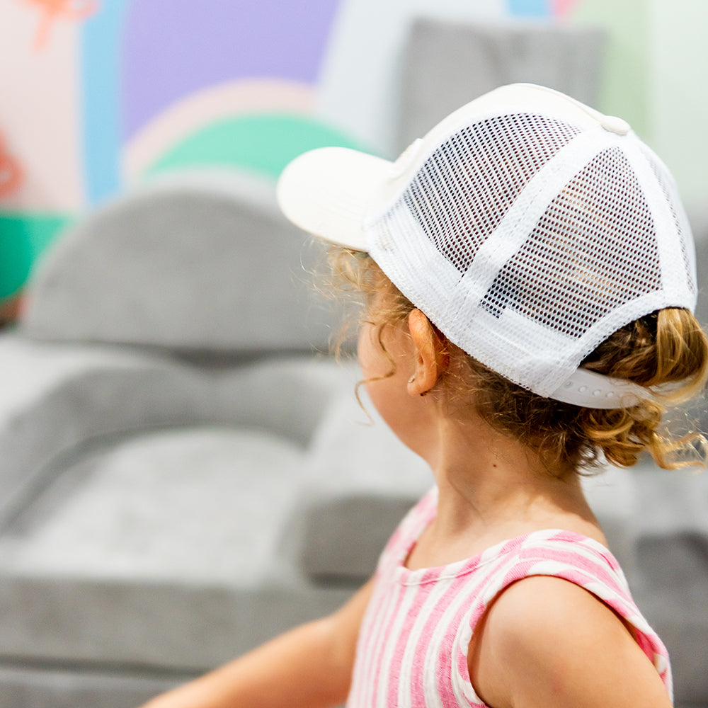 Child wearing the Wheat Trucker Cap from the side and back showing its breathable white mesh