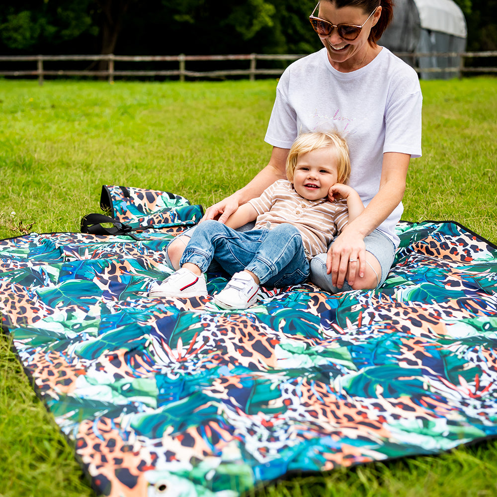 Child sitting on the Wild Adventure Mat outdoors