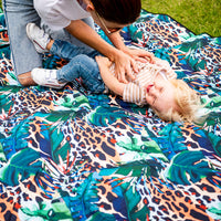 Child sitting on the Wild Adventure Mat outdoors